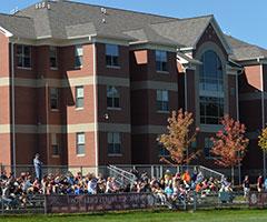 Students in bleachers cheering on a sports team